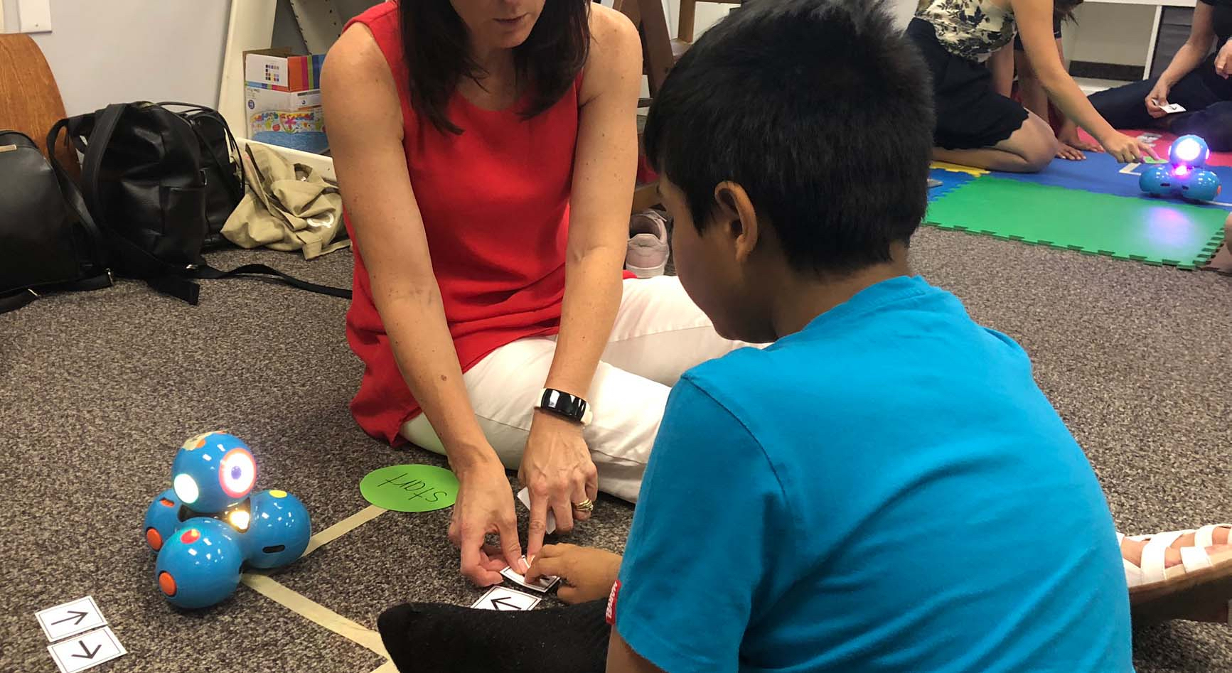Providing separate working stations to give students a chance to focus on one robot at a time Facilitators are working with students in separate stations to work with robots